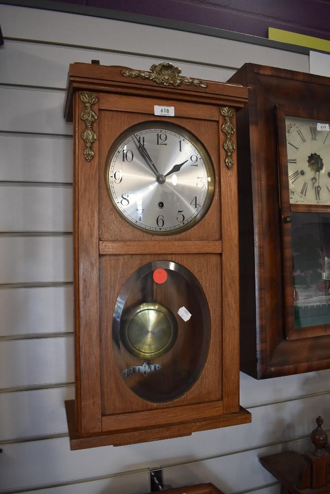 A wood framed wall clock with pendulum