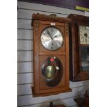 A wood framed wall clock with pendulum