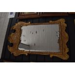 A Georgian mirror having Chippendale style carved gilt and gesso frame with silver backed mirror