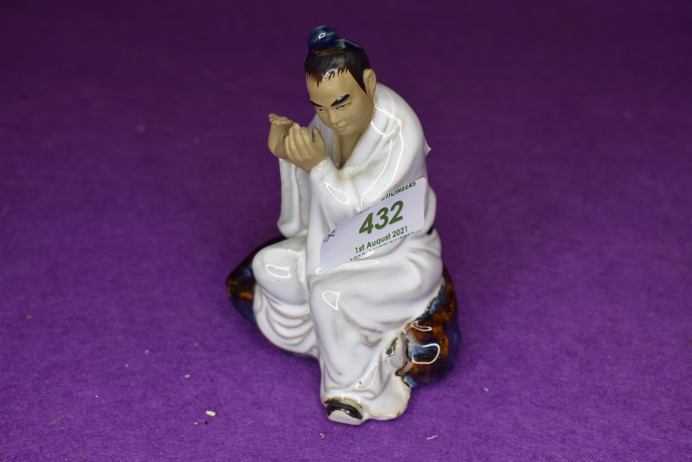 A vintage Chinese figure of a man playing instrument in a mudman style signed Wan Jiang to base