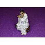 A vintage Chinese figure of a man playing instrument in a mudman style signed Wan Jiang to base