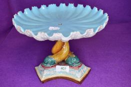 A Victorian table centre supported by three mythical sea creatures and bearing a Royal Worcester