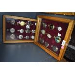Two glazed display cases containing twenty one pocket watches or time pieces