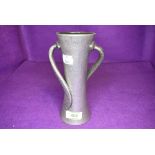 An arts and crafts style Tudric pewter vase having hammered body with double twist arms 17cm tall