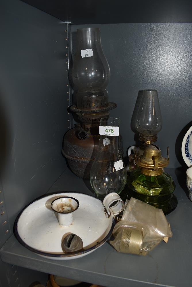 A selection of oil lamps and candle burners including green glass well