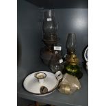 A selection of oil lamps and candle burners including green glass well