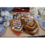 Five oak and hand painted crest shields and two similar hand painted motto crests