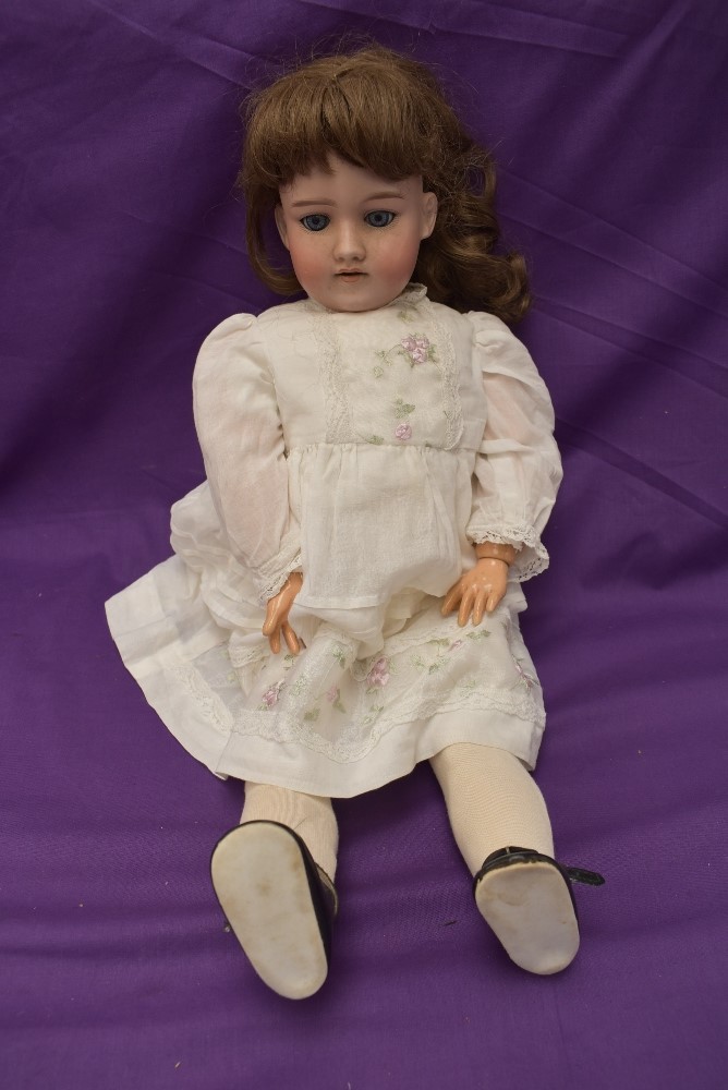 An early 20th century German Armand Marseille Bisque Socket Headed Doll having sleep blue eyes, open