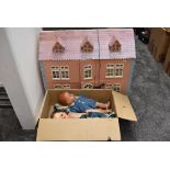 A modern wooden two storey dolls house having plastic and wooden furniture and accessories along