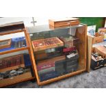 A vintage wood and glass display cabinet having three glass shelves with mirror base