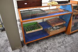 A vintage wood and glass display cabinet having three shelves