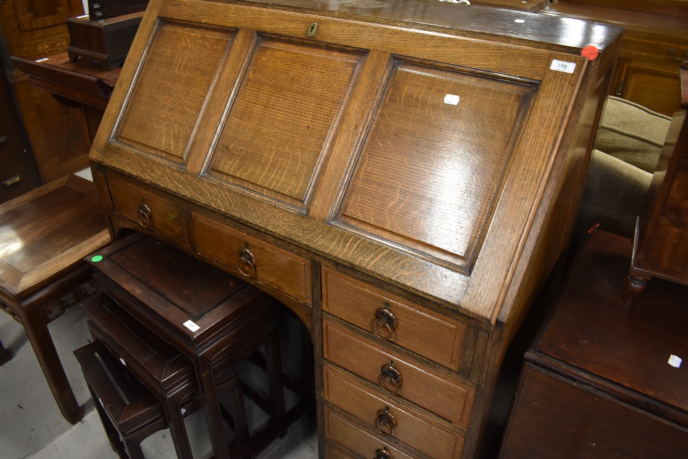 An early 20th Century oak bureau having panelled flap, interesting compartmental interior , heavy