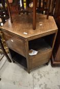 An early to mid 20t Century oak low bookcase of hexagonal form with alternate panels