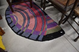 Two vintage demi lune hearth rugs, in vibrant colours