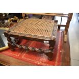 A Victorian carved mahogany footstool having bergere top and barley twist frame