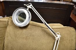 A vintage anglepoise magnifying lamp, designed to be desk mounted