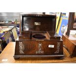 A 19th Century mhogany tea caddy of sarcophagus form with mother of pearl inlay and fitted interior