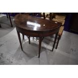 A 19th Century mahogany demi lune fold over tea table having inlaid detailing on tapered legs