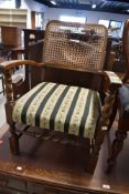 An early 20th Century oak low seat carver chair having bergere style canework back (af) and woolwork