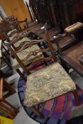 A set of six late 19th or early 20th Century mahogany dining chairs having scroll ladder backs