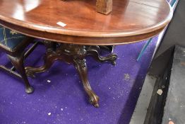 A Victorian loo table having turned and carved pedestal base on scroll legs