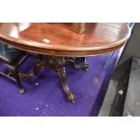 A Victorian loo table having turned and carved pedestal base on scroll legs