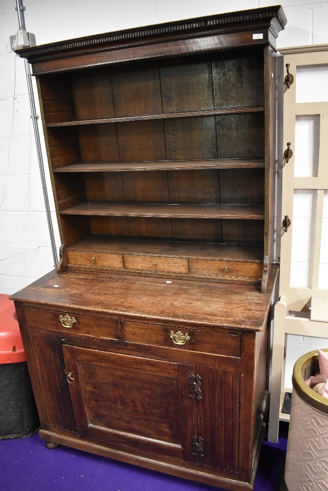 A 19th Century oak dresser of naive form, having utility style base on bun feet