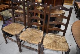 Three 19th Century oak ladder back chairs having rush seats
