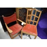 A light oak carver chair having red leather upholstery and a similar lattice back dining chair