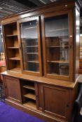 An impressive late Edwardian library book case and cupboard base having oak carcass with sliding