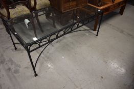A wrought iron framed coffee table having glass top