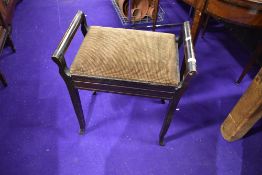 A traditional stained frame piano stool having moquette lid