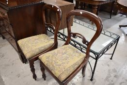 A pair of Victorian balloon and carved back dining chairs with mahogany frames