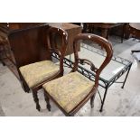 A pair of Victorian balloon and carved back dining chairs with mahogany frames