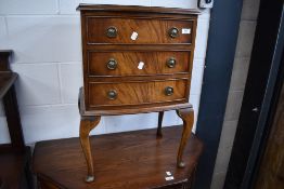 A Reprodux reproduction bedside chest of three drawers on stand