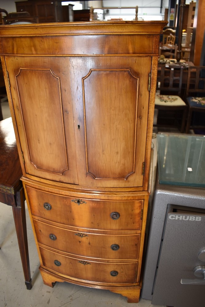 A modern yew wood cocktail cabinet having double cupboard and internal light