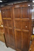 An early 20th Century oak wardrobe having panelled doors