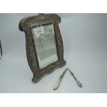 An Edwardian silver table mirror of shaped rectangular form having moulded water lily and bird