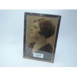 A silver photograph frame of plain rectangular form having wooden easel back, Birmingham 1925,