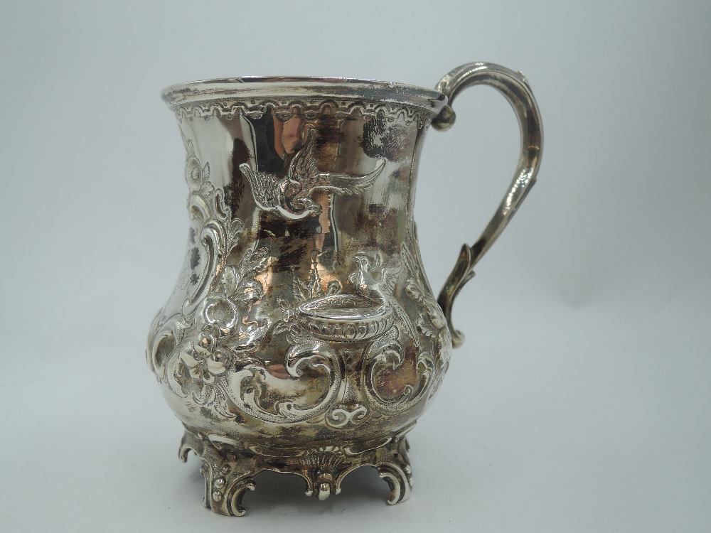 A Victorian silver Christening mug of baluster form having repousse floral, scroll and