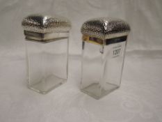 Two Victorian glass toiletry pots of tall rectangular form having plannished tops with monogrammed
