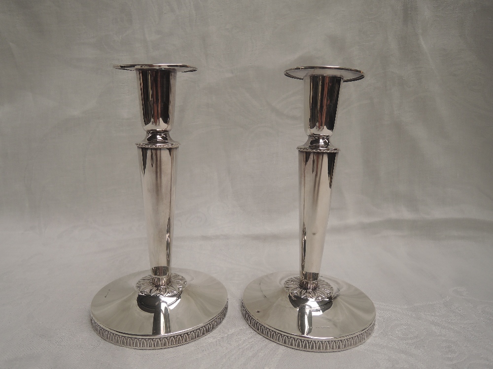 A pair of Swedish silver candle sticks having tapered columns to weighted circular bases, date