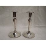 A pair of Swedish silver candle sticks having tapered columns to weighted circular bases, date
