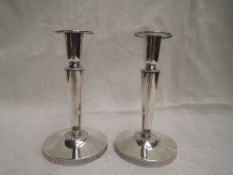 A pair of Swedish silver candle sticks having tapered columns to weighted circular bases, date