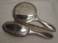 A Pakistani silver three piece dressing table set having an engraved border, and presentation