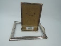 A small silver photograph frame of plain rectangular form having wooden back with easel stand,