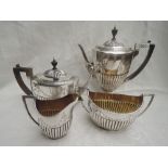 A Victorian silver four piece tea and coffee set having half gadrooned bodies with engraved swag