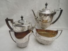 A Victorian silver four piece tea and coffee set having half gadrooned bodies with engraved swag