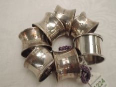 A set of six silver napkin rings of plain form, Birmingham 1945, (1 AF), and a white metal napkin