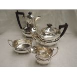 A silver four piece tea set of canted ovoid form having gadrooned rims, wooden handles and knops and